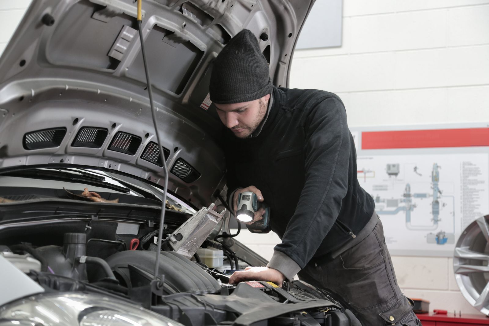 Technician inspecting a vehicle in a bright workshop